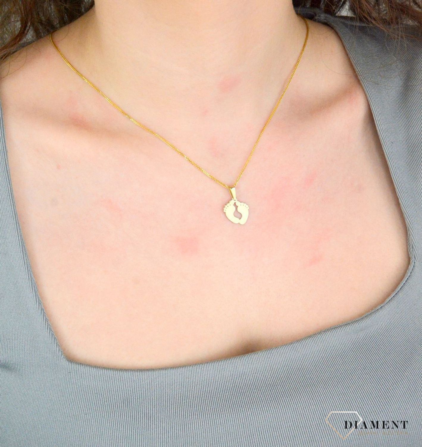 Zawieszka złota damska stopy stópki próba 375, ZA 5602 375  Piękny, złoty wisiorek o ciekawym wzorze wykonany z żółtego złota. Zawieszka w formie stópek. Wisiorek został wykonany z wysokiej jakości złota próby 375.1.jpg